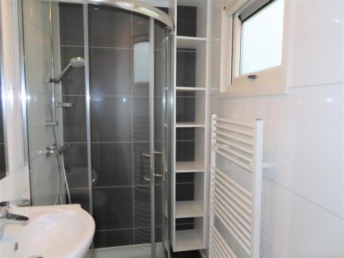 La salle de bains est pourvue d'une douche et d'un lavabo. dans l'établissement Familie Chalet Oostkapelle OK30, à Oostkapelle