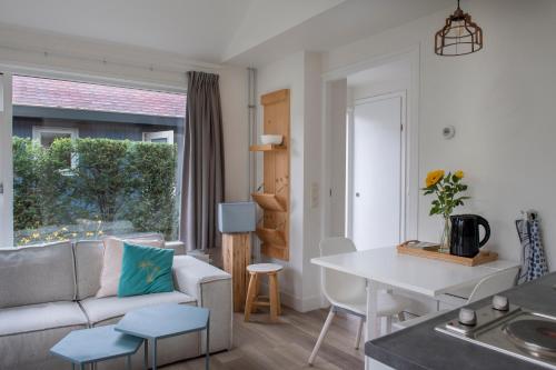 een woonkamer met een bank en een tafel bij Soeren Lounge in Eerbeek