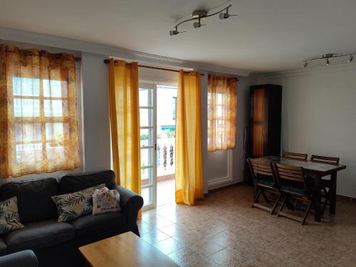 una sala de estar con un sofá y una mesa en Orion, en Puerto Naos