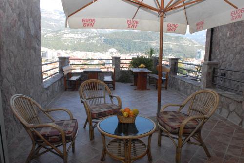 a patio with chairs and a table with a bowl of fruit at Contessa Apartments in Budva