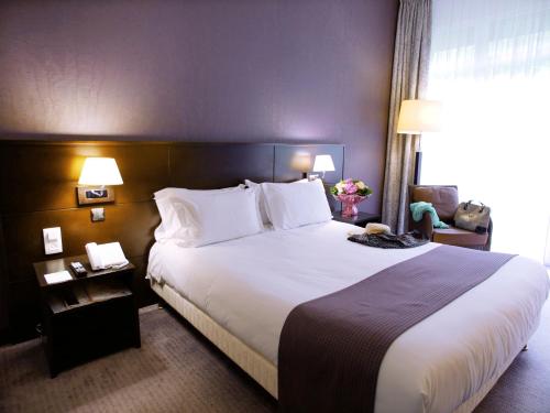 a hotel room with a large bed with white pillows at Holiday Inn Resort le Touquet, an IHG Hotel in Le Touquet-Paris-Plage