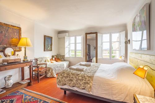 ein Schlafzimmer mit einem Bett und ein Wohnzimmer in der Unterkunft La Maison du Prince in Grimaud