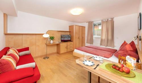a living room with a red couch and a table at Elto Appartements in Kaprun