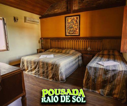 a hotel room with two beds in a room at Pousada Raio de Sol in Jaguarão