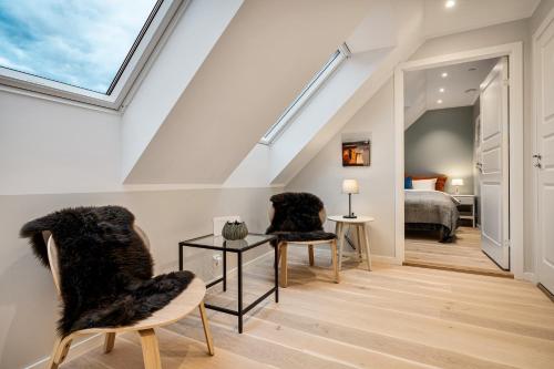 una camera con due sedie e un letto e un lucernario di Keyser Apartments 8 a Bergen