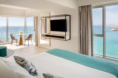 a hotel room with a large bed and a view of the ocean at Arrecife Gran Hotel & Spa in Arrecife