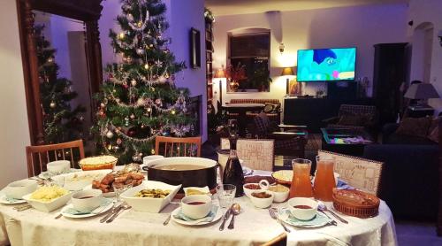 a table with a christmas tree in a living room at Dom Gościnny Hansel & Gretel in Kallinowen