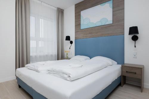 Un pat sau paturi într-o cameră la Apartamenty Aquamarina Onyx by Renters