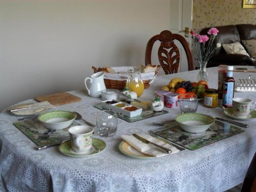 Higher Chapel Farm في Calstock: طاولة عليها قماش الطاولة البيضاء مع الطعام
