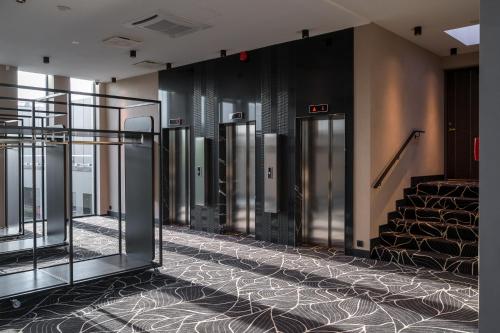 a row of elevators in a building with a staircase at Movenpick Hotel Tallinn in Tallinn