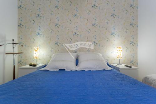 a bedroom with a blue bed with two white pillows at Luxury apartment in front of the beach in Melenara