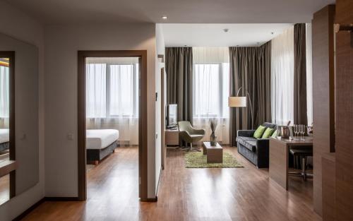 a living room with a couch and a bed in a room at Ramada Encore Kyiv in Kyiv