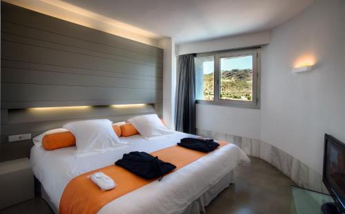 a hotel room with two beds and a window at Hotel Spa Calagrande Cabo de Gata in Las Negras
