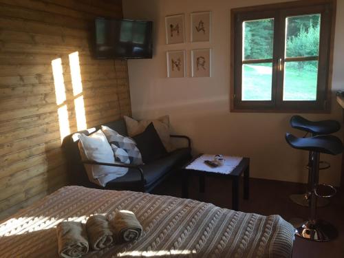 a bedroom with a bed and a couch and a chair at Bungalovi Gučevski pogled - Banja Koviljača in Rupavci