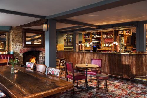 a bar with a fireplace and a table and chairs at Royal Seven Stars Hotel in Totnes