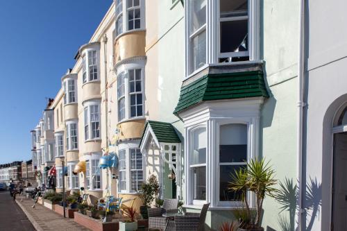 a row of houses with plants on a street at Channel View Guest House in Weymouth