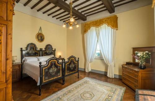 a bedroom with a bed and a dresser and a window at Villa Ines charme near Lucca in Altopascio