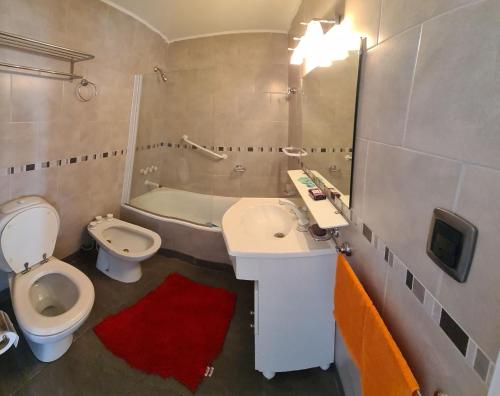 a bathroom with a sink and a toilet and a tub at EdenMDQ in Mar del Plata