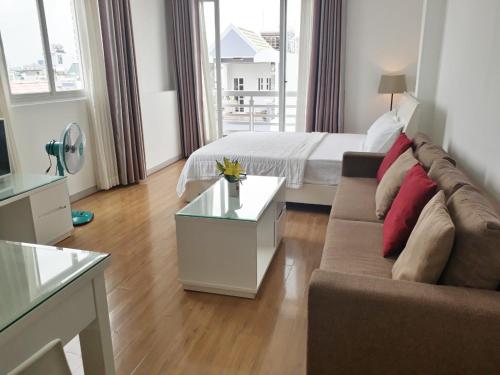un soggiorno con un divano e un letto di Saigon Apartments 2 ad Ho Chi Minh