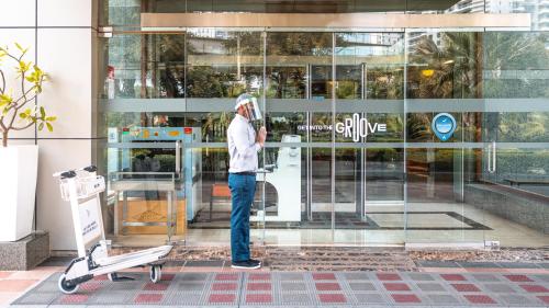 a man standing next to a skateboard in front of a building at ibis Chennai OMR in Chennai