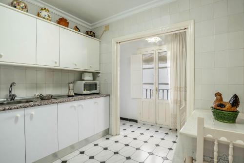 a kitchen with white cabinets and a sink at Casa Romero in Vejer de la Frontera