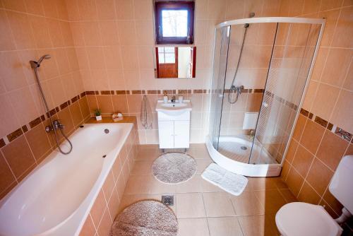 y baño con bañera, ducha y lavamanos. en Edelin Country House, en Becskeháza