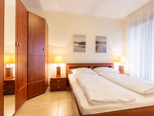 a bedroom with a large bed with two white pillows at VacationClub - Olympic Park Apartament A202 in Kołobrzeg