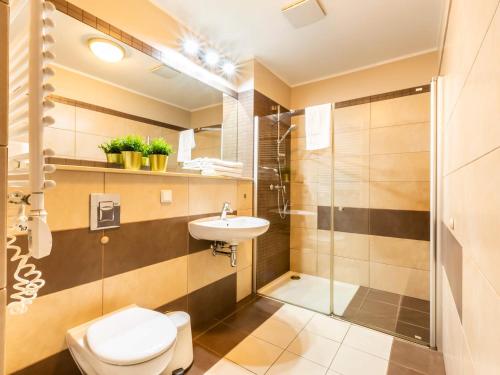 a bathroom with a toilet and a sink and a shower at VacationClub - Olympic Park Apartament A202 in Kołobrzeg