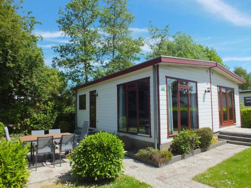 a tiny house with a patio and a table at Camping de Vogel in Hengstdijk