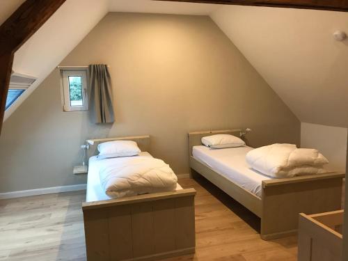 two beds in a room with a attic at Naanhover Beemden in Nuth