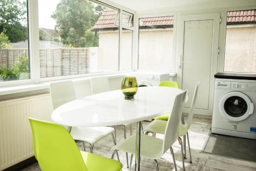 a white dining room with a white table and chairs at The Tushmore in Crawley