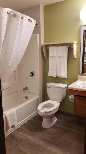 a bathroom with a toilet and a tub and a sink at WoodSpring Suites Kansas City Lenexa in Lenexa