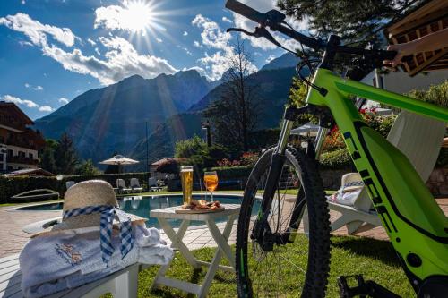 ein Fahrrad neben einem Tisch mit einem Getränk geparkt in der Unterkunft Hotel Du Lac in Molveno