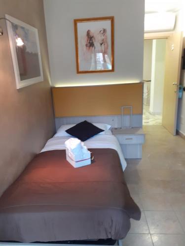 a bedroom with a bed with a pile of towels on it at Rainbow Sweet Rooms in Valmontone