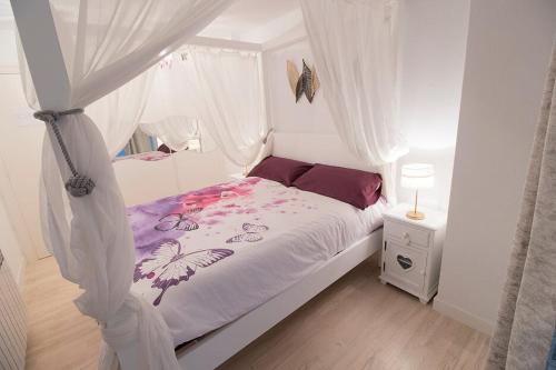 a white bedroom with a bed with a canopy at "El Rincon Apartament " in Pamplona
