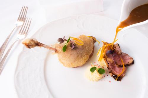 a white plate with food on a table at Hotel Du Lac in Molveno