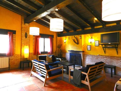 sala de estar con sillas, TV y sofá en Hostel El Lago, Caceres, en Jaraíz de la Vera