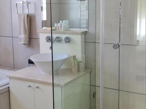 a white bathroom with a sink and a shower at Wilwou At Sea in Gordonʼs Bay