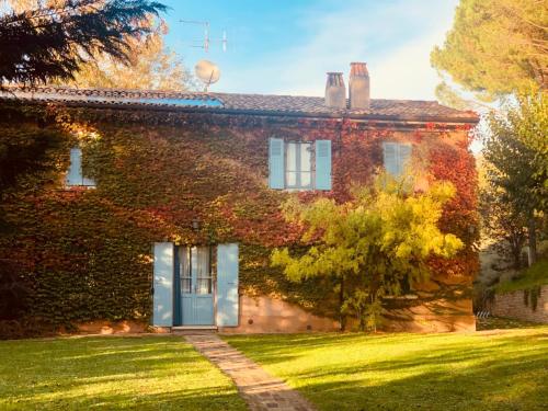 una casa in mattoni con una porta blu in un cortile di Alloggio Al San Girolamo a Longiano