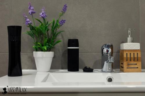 Un mostrador de baño con un lavabo con flores. en UrbanLux Feria, en Albacete