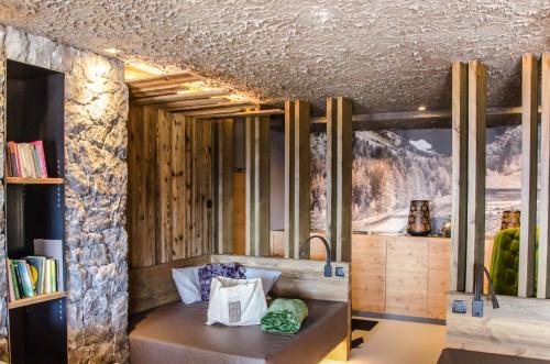 Pokój z ławką i kamienną ścianą w obiekcie DAS GERSTL Alpine Retreat w mieście Malles Venosta