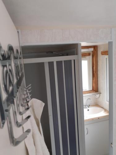 a bathroom with a bunch of knives hanging on a wall at restyled bohemian mobil home la vie en rose in Montcléra