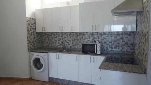 cocina con lavadora y fregadero en APARTAMENTO ALEGRANZA, en Orzola