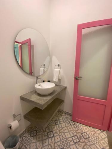 a bathroom with a sink and a red door at Casa Celeste Honda in Honda