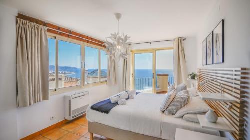 een slaapkamer met een groot bed en uitzicht op de oceaan bij Casa Ventanas al Mediterraneo Nerja by Ruralidays in Nerja