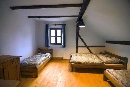 a room with three beds and a window at Horská chalupa Jeřabina in Horní Blatná