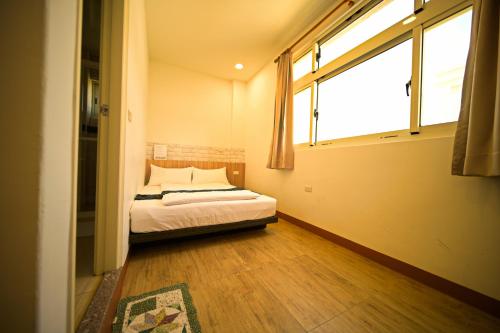 a bedroom with a bed and a large window at 嚨口秘境觀海民宿The heart of the sea in Jinning