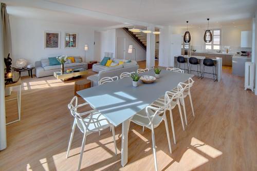 een keuken en een woonkamer met een tafel en stoelen bij IMMOGROOM - Magnificent 180m duplex apartment - Parking - Air conditioning in Cannes