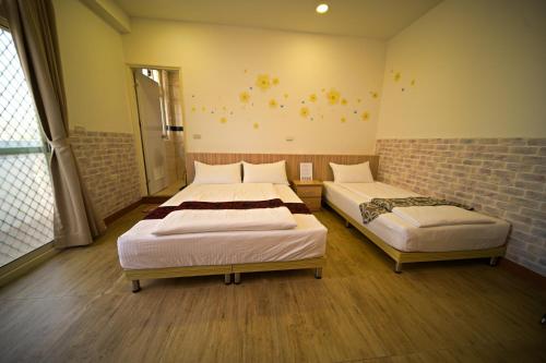 a bedroom with two beds and a brick wall at 嚨口秘境觀海民宿The heart of the sea in Jinning