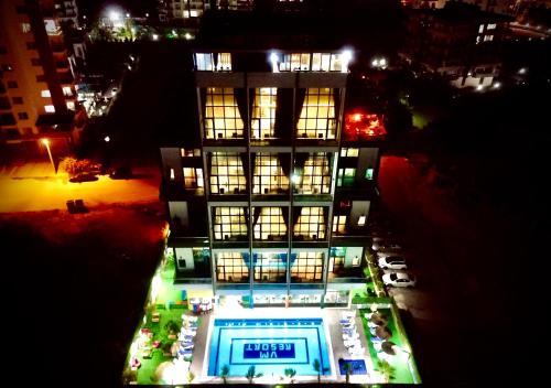 un edificio con una piscina delante de él por la noche en Vm Resort Otel Mersin, en Mersin